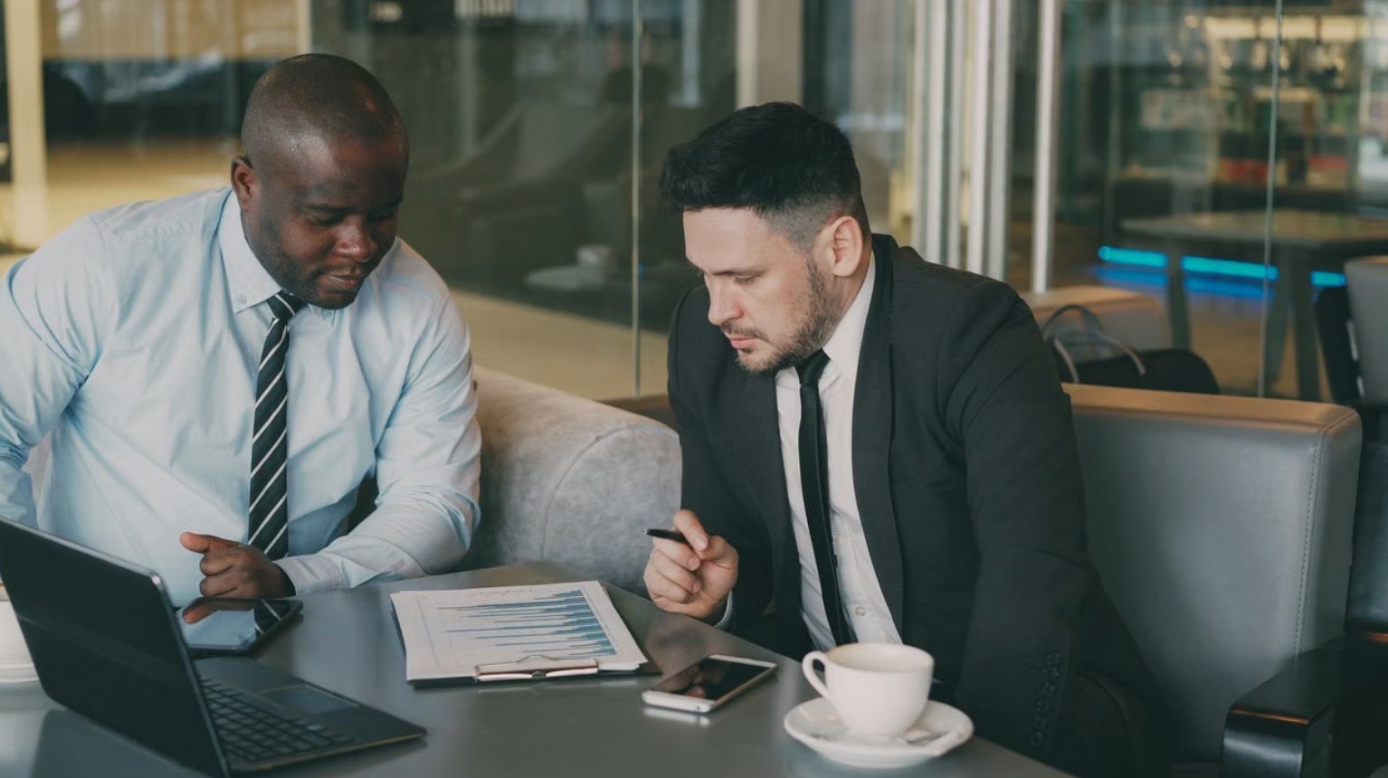 Two advisers reviewing a tax computation over a laptop